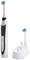 Electric toothbrush with charging station and replacement brush head. Black design with white accents.