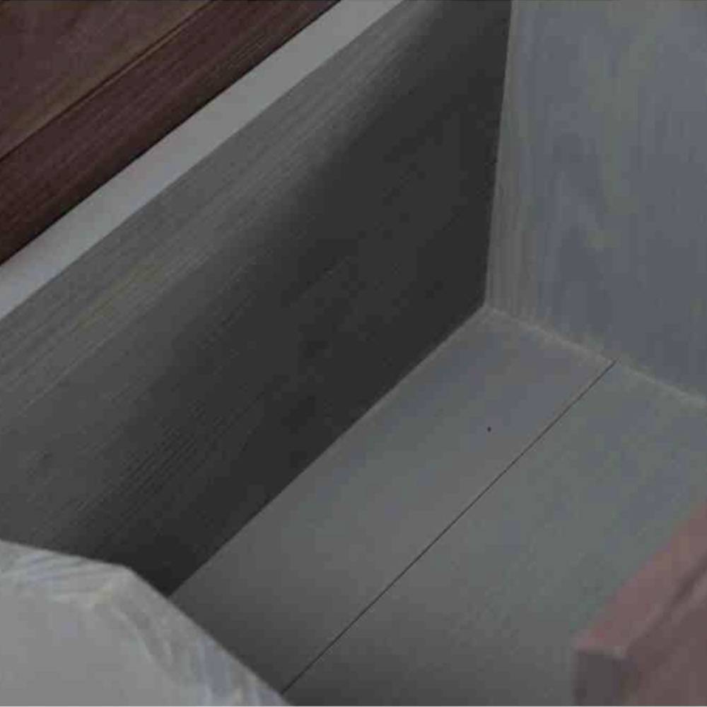 An empty, open wooden drawer in a piece of furniture, photographed from above. Simple, modern design.