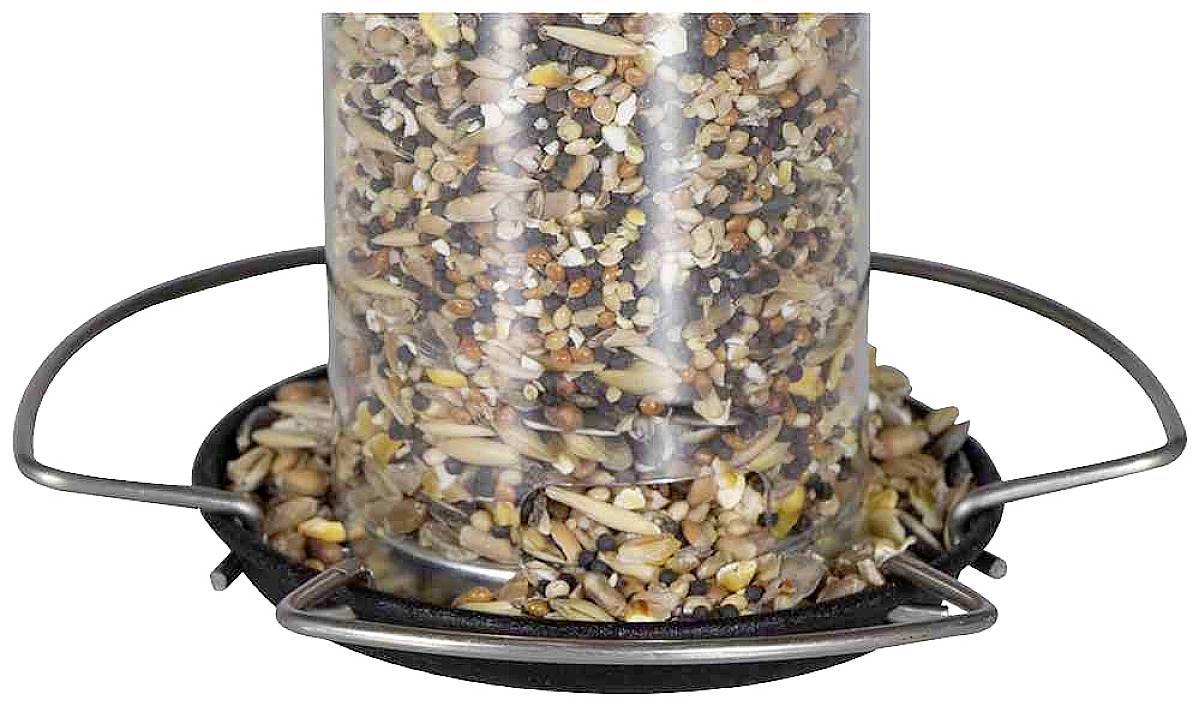 A translucent bird feeder, filled with grains and seeds, mounted on a black base with metal hanging hooks.