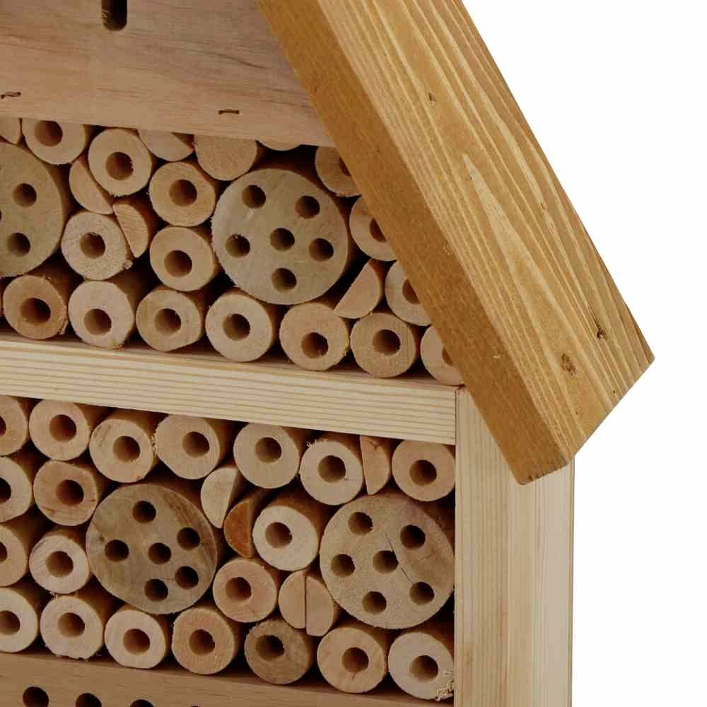 An insect hotel made of wooden discs and holes, serving as a refuge for wild bees and other beneficial insects.