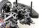 Close-up of a remote-controlled car's front axle, showing shock absorber, suspension and wheel with visible components and wiring.