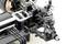 Close-up of a remote-controlled car chassis with details of the suspension and suspension systems. Focus on mechanical components.