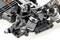 Close-up of a remote-controlled vehicle chassis with shock absorbers, suspension, and metal components revealing technical details.