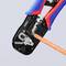 A blue and red crimping pliers is gripping an orange cable. It is a tool for cable and wire connections.