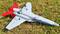 A model aeroplane with red tail fins is lying on a grass field. 'U.S. Air Force' is written on the fuselage.