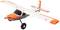 A model aircraft with an orange and white design, large wheels, and a propeller, is in focus, possibly for hobby or exhibition purposes.