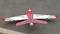 A small model aeroplane with a red and white chequered pattern and the inscription 'VIPER JET' on the wings is standing on the road.