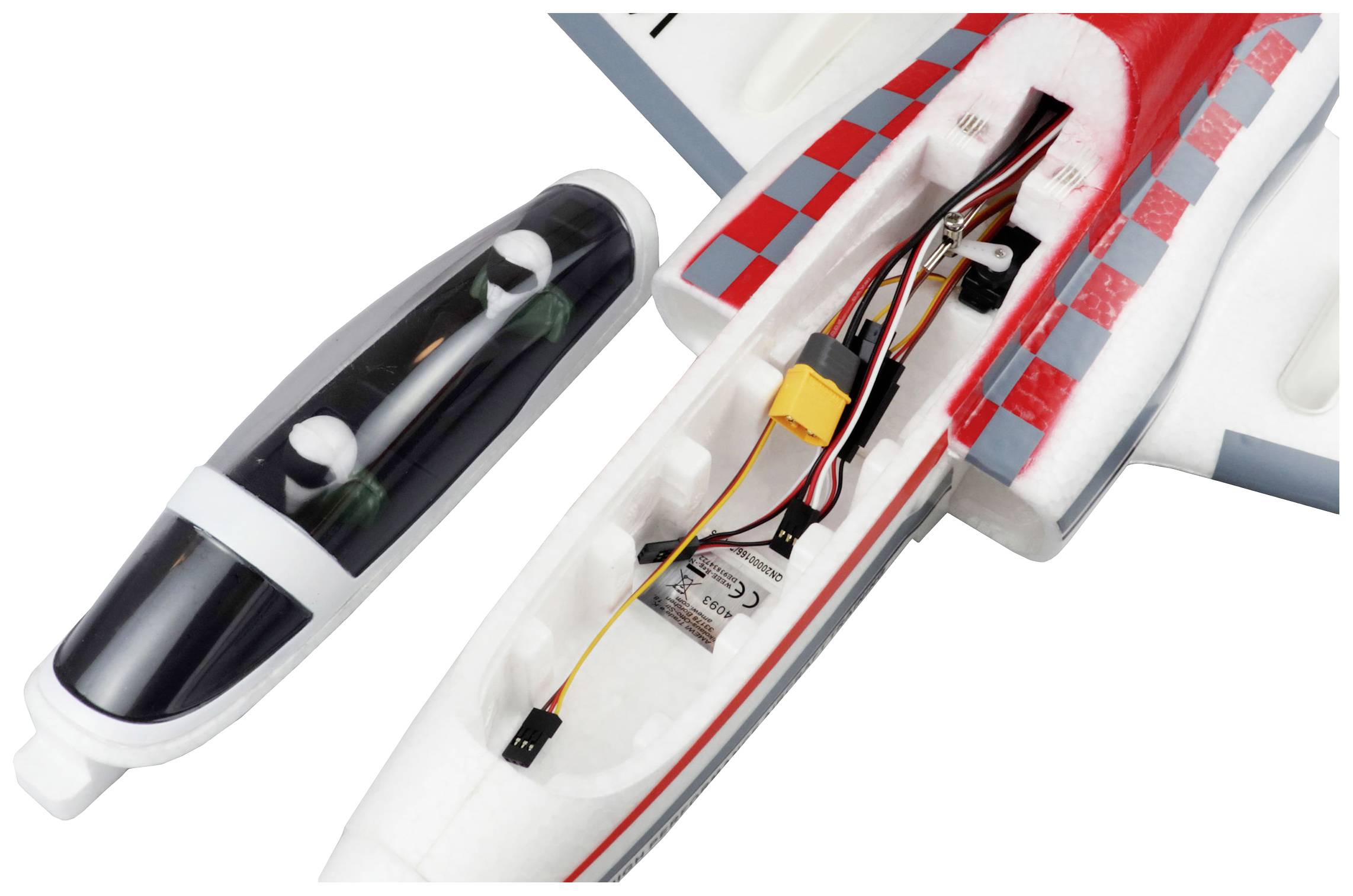 Model aircraft with an open fuselage revealing electronic components and wiring. Removable cockpit canopy positioned alongside.