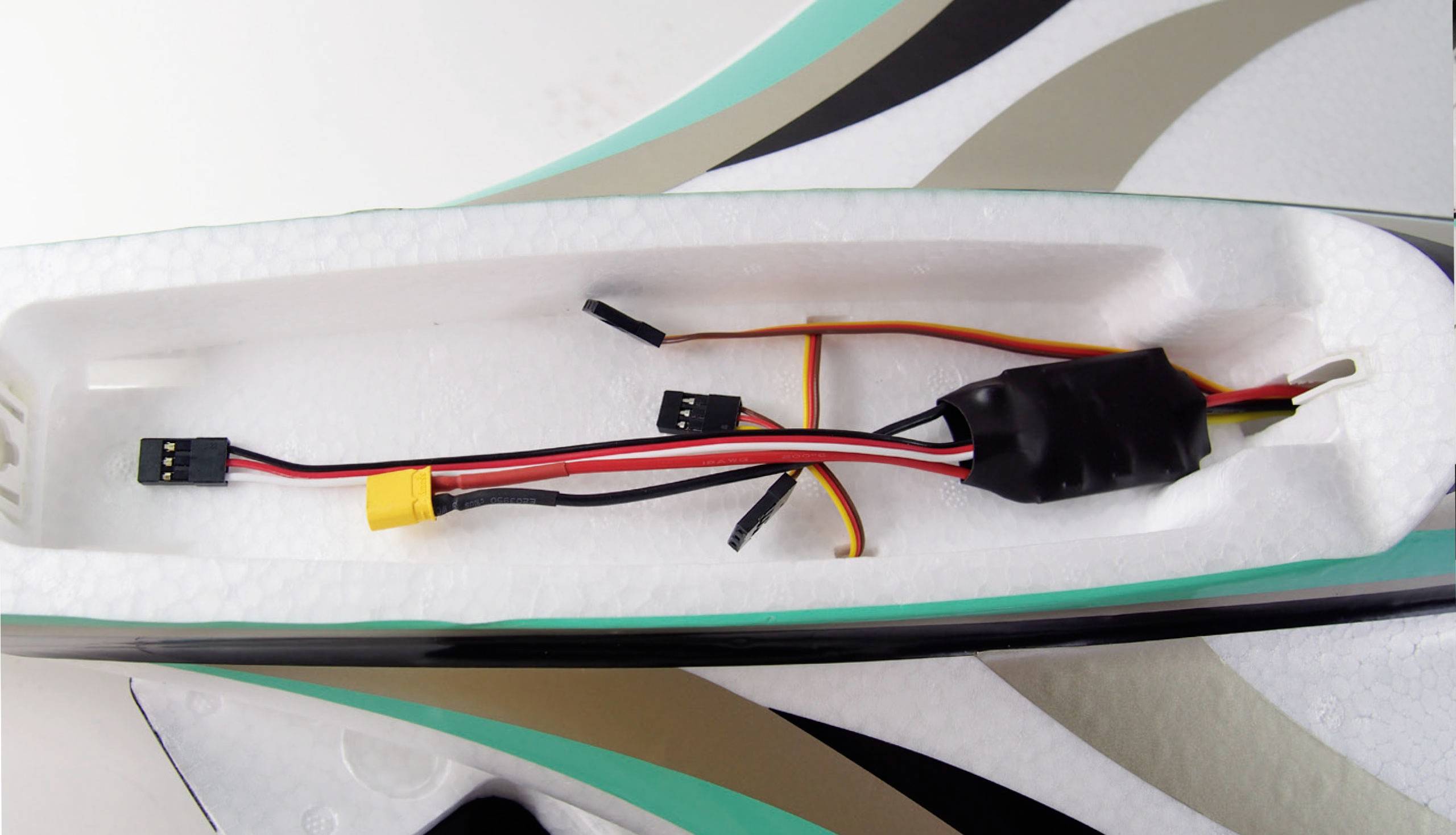 An electrical wiring system with multiple plug connections in a foam compartment of a model aircraft.