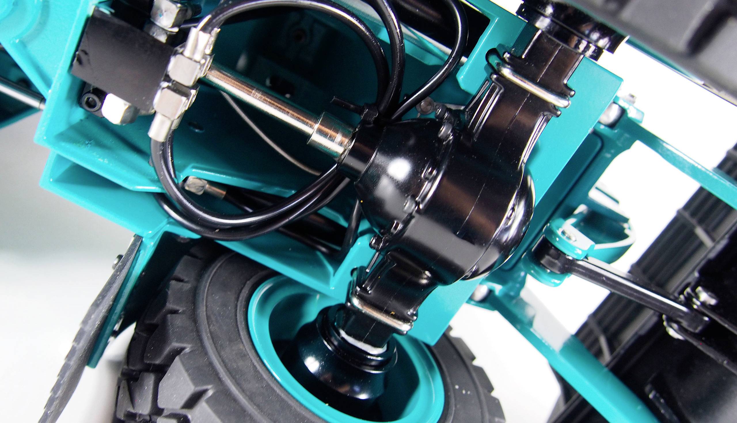 Close-up of a vehicle's suspension system in blue and black, showing springs, shock absorbers, and tyres.