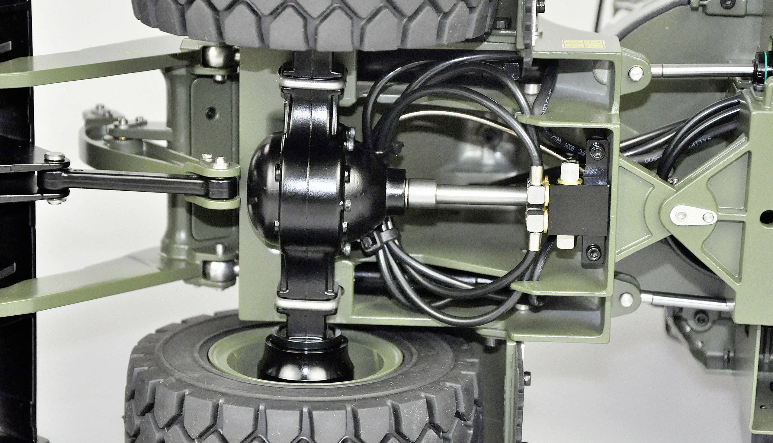 Close-up view of a vehicle showing axles and suspension. Reveals details of suspension mechanics and shock absorber structure.