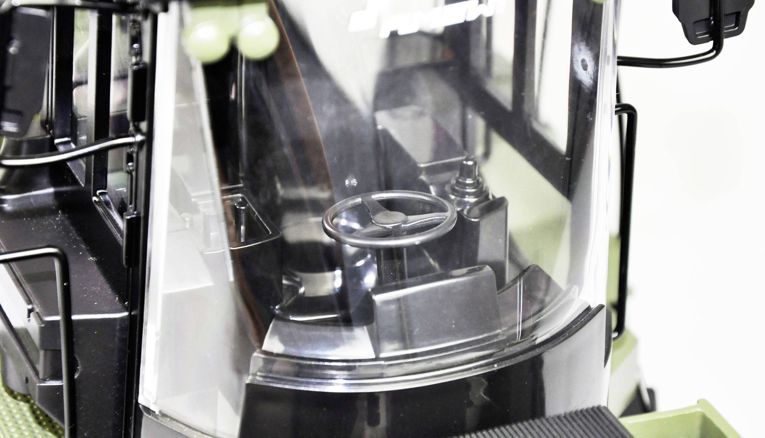 Close-up of an agricultural vehicle's cockpit with steering wheel. Part of the dashboard is visible.