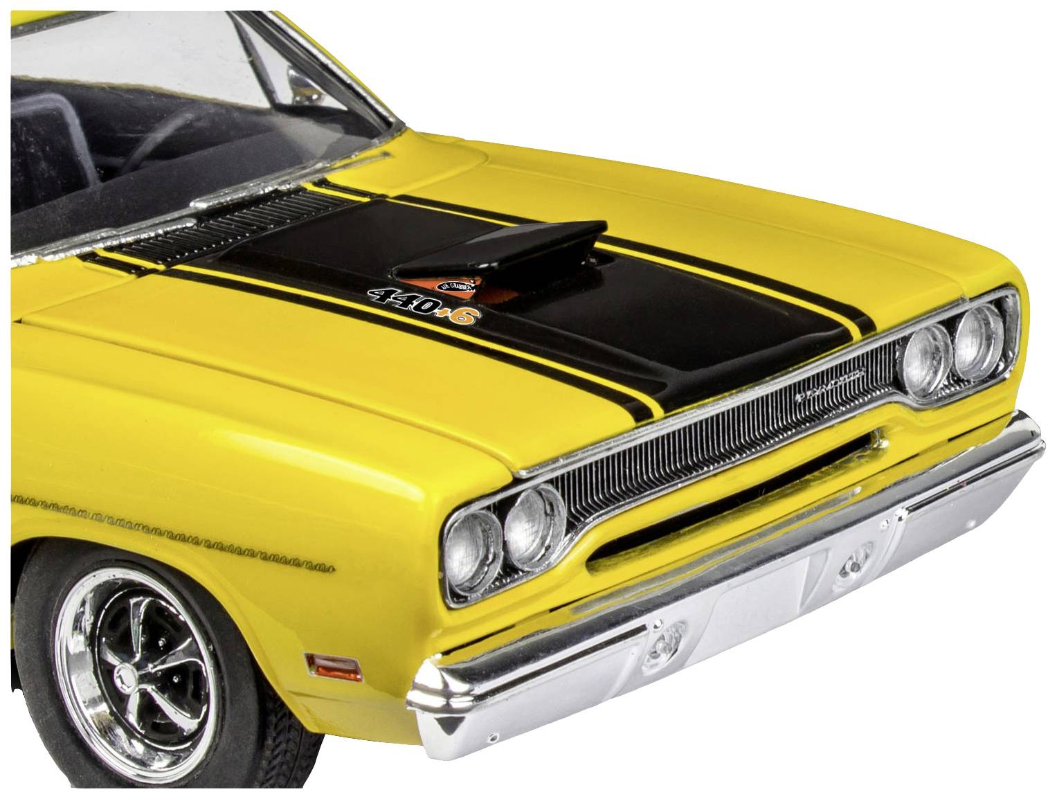 Yellow vintage car with a black bonnet and distinctive air intake. Front view with a chrome-gleaming bumper.