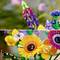 Colourful LEGO flowers in close-up: a purple lupin, yellow sunflower and others, against a blurred background.