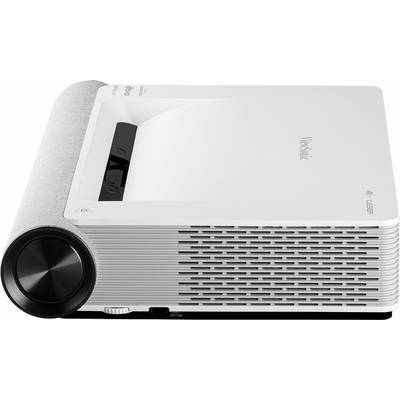 A white projector with ventilation slots on the side, a black control panel on top, and a large focus wheel at the front.
