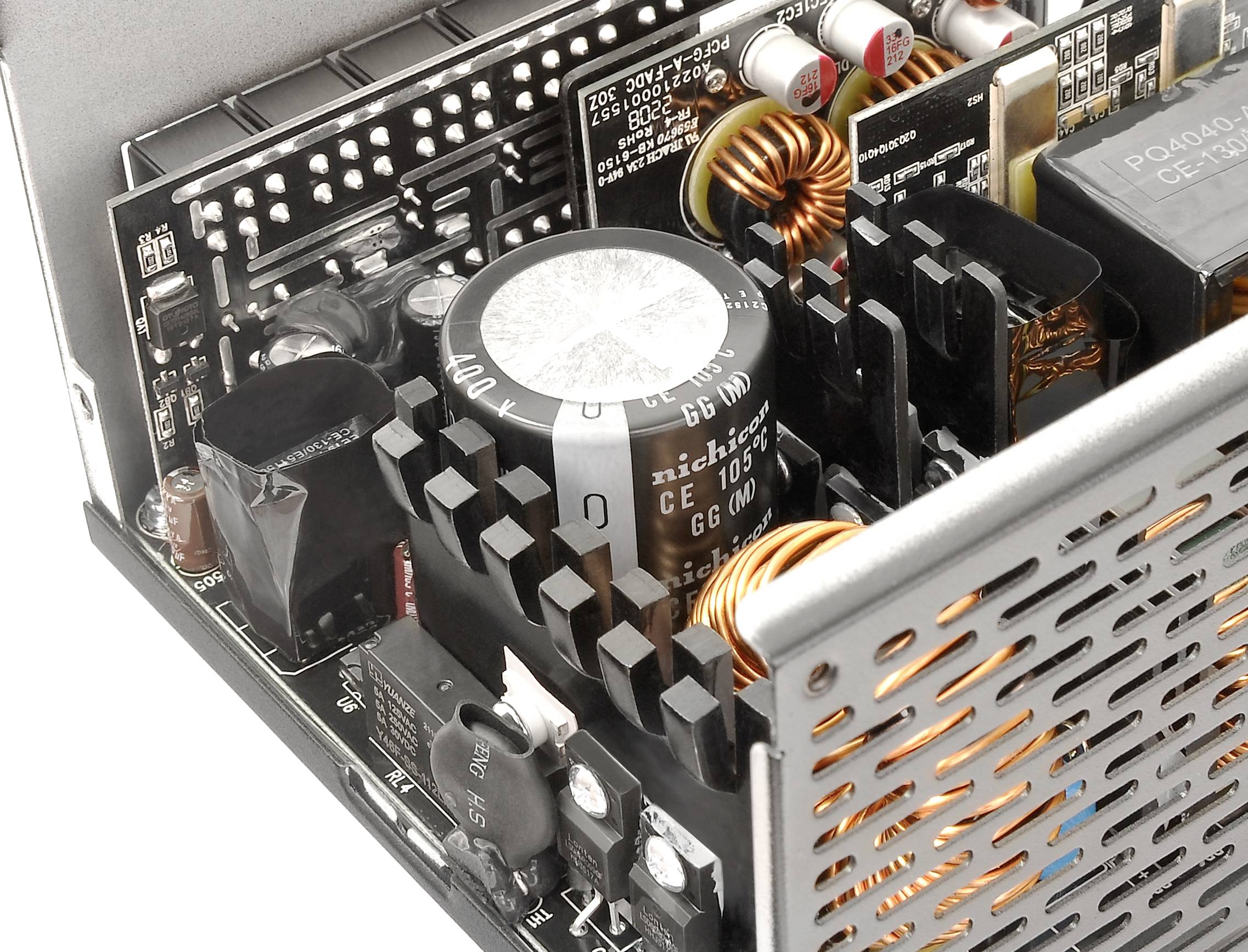 Close-up of a computer power supply circuit board with various electronic components such as capacitors, inductors, and heatsinks.