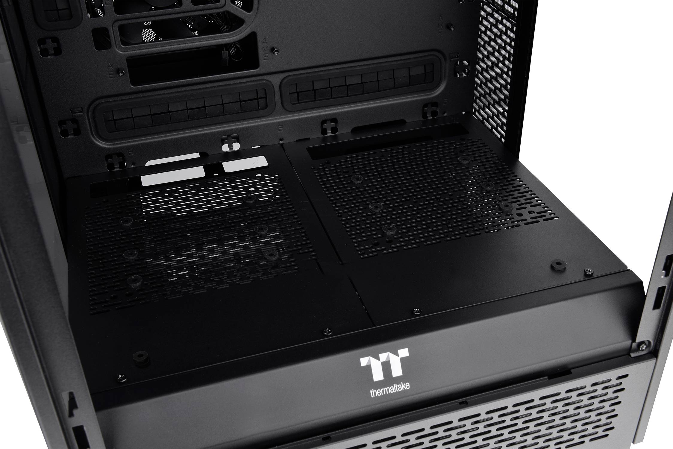 Interior view of a black Thermaltake PC case, showing cable management options and ventilation slots.