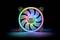 A computer fan with RGB lighting that illuminates in various colours. The manufacturer's logo is situated in the centre.