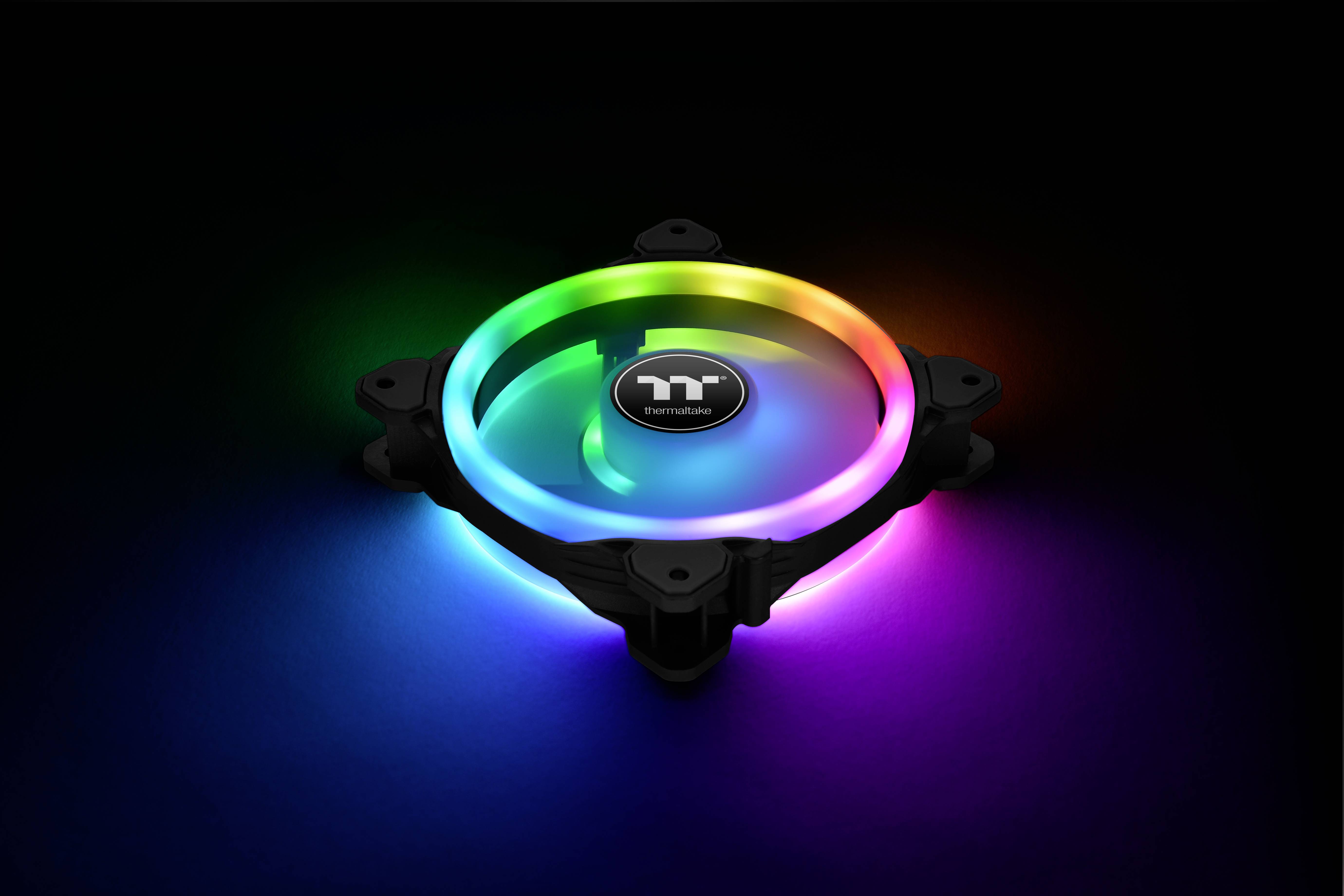 A computer fan with RGB lighting displays vibrant colours against a dark background. The logo in the centre is clearly visible.