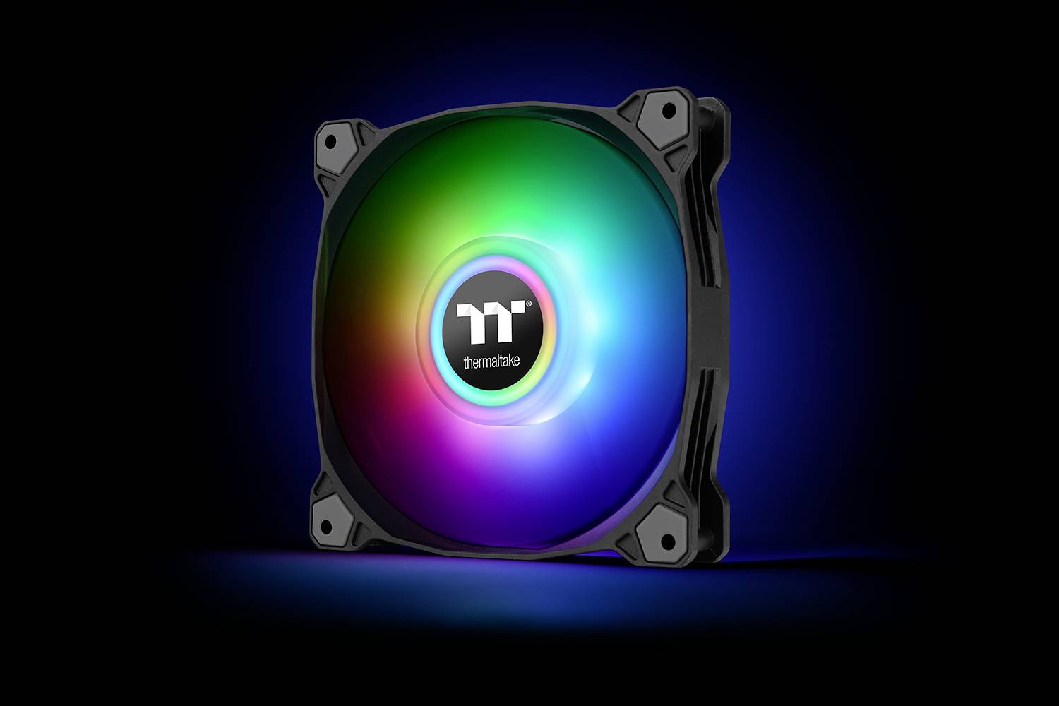 A vibrant, luminous computer fan by Thermaltake against a black background, displaying a shimmering RGB colour spectrum.