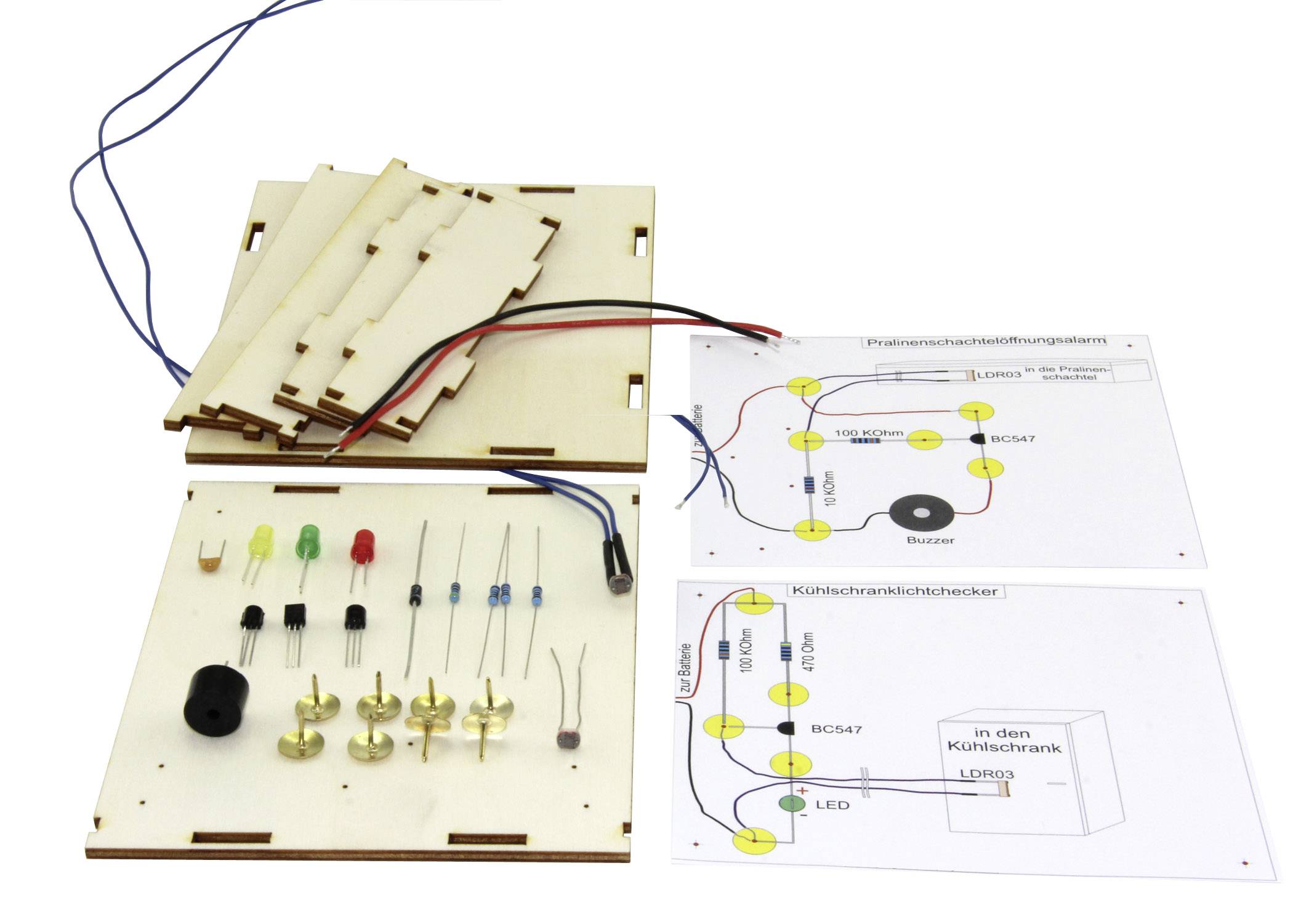 Electronic kit with circuit board, LEDs, resistors, and circuit diagrams for a project. Predominantly white in colour.