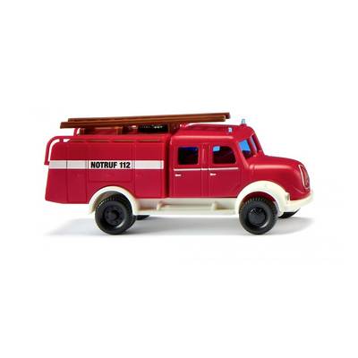 Toy fire engine with the side inscription 'Emergency 999'. It is red with white details and has a ladder on the roof.
