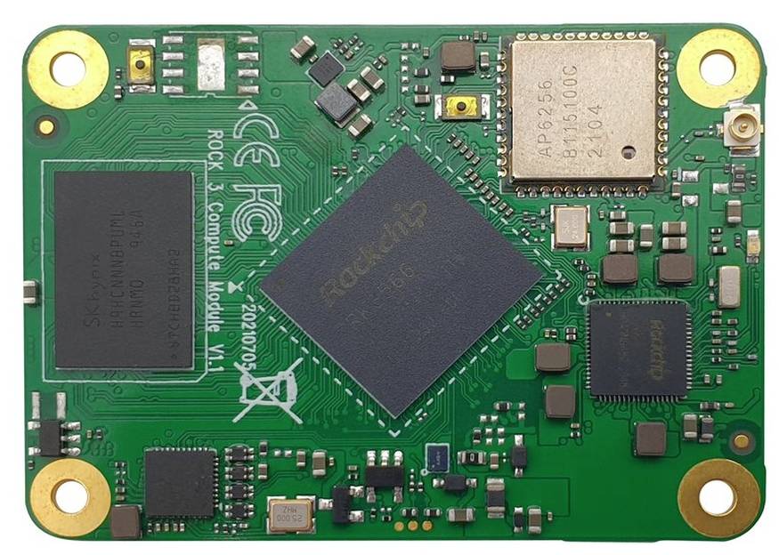 A green computer module with electronic components and a central black chip, surrounded by smaller parts.