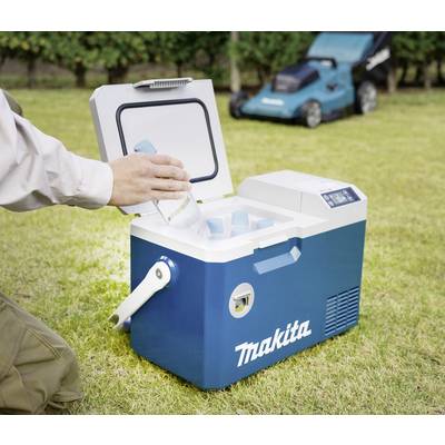 A person places a bottle in a blue Makita cool box on a grassy area. A lawnmower stands in the background.