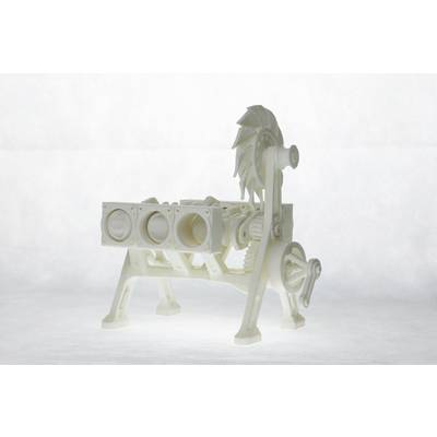 A white plastic model of an engine with visible cylinders, gears, and a fan wheel. The model is positioned on a table.