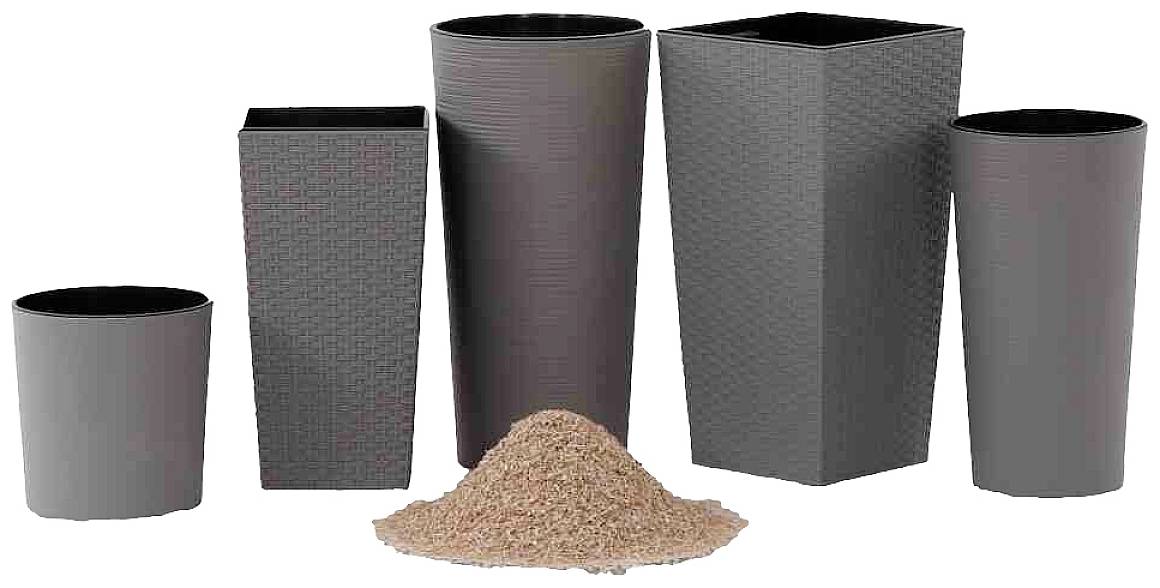 A group of five plant pots of different shapes and colours stands behind a pile of soil.
