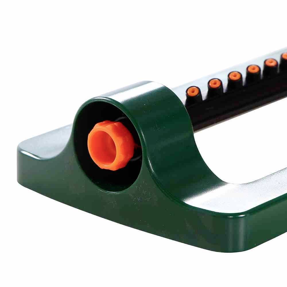 A sprinkler in green and orange for irrigation, with multiple nozzles on a pivoting bar.