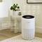 A white Bosch air purifier in a living room. Text informs about the removal of 99.95% of harmful particles from the air.
