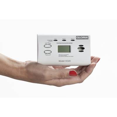 A hand is holding a carbon monoxide detector with a display, model KO2D by GLORIA.