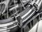 Close-up of a bicycle tyre with a metal rim and black straps securing the tyre. Silver spokes are visible.
