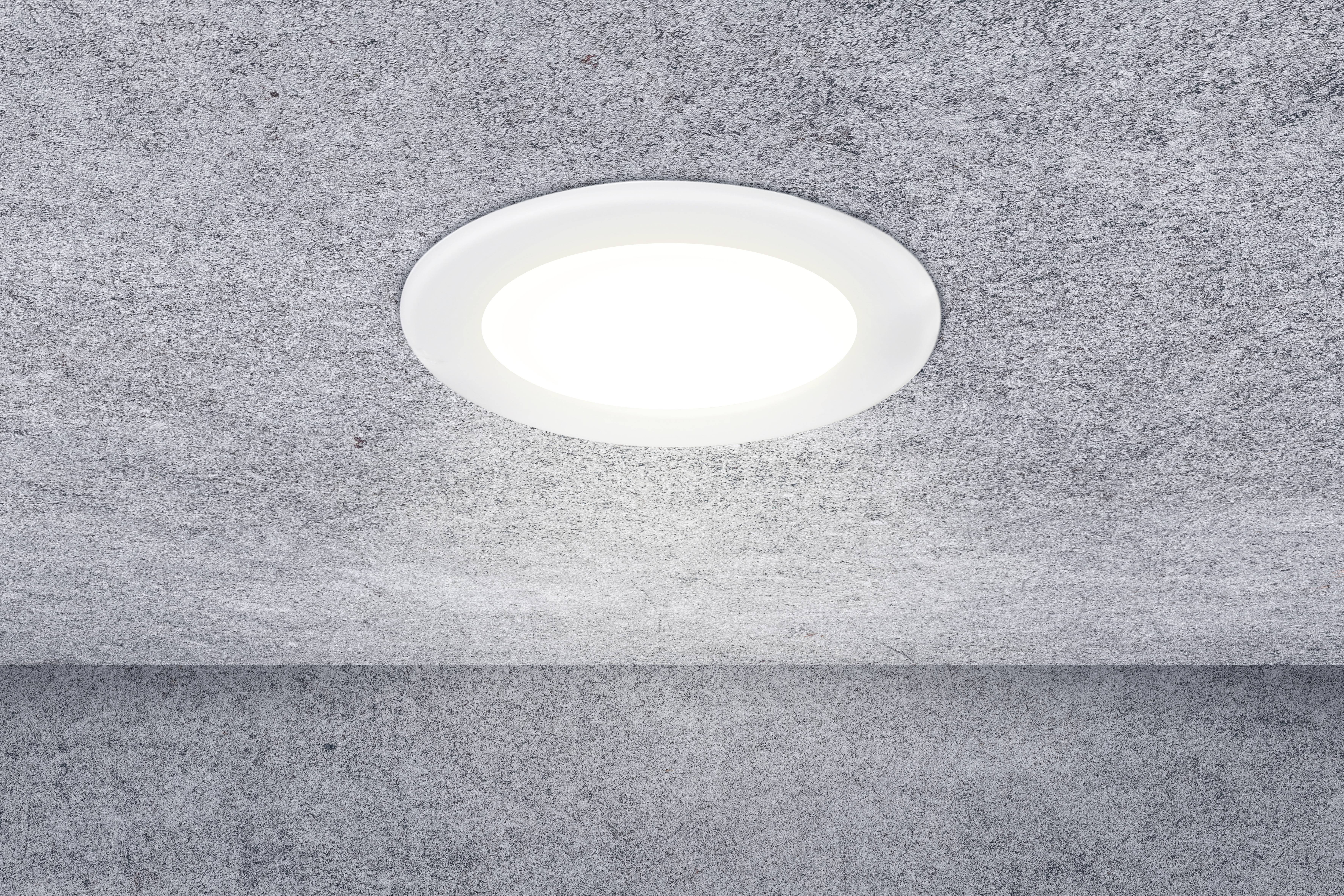 Round ceiling light mounted on a grey ceiling, which is brightly illuminated.