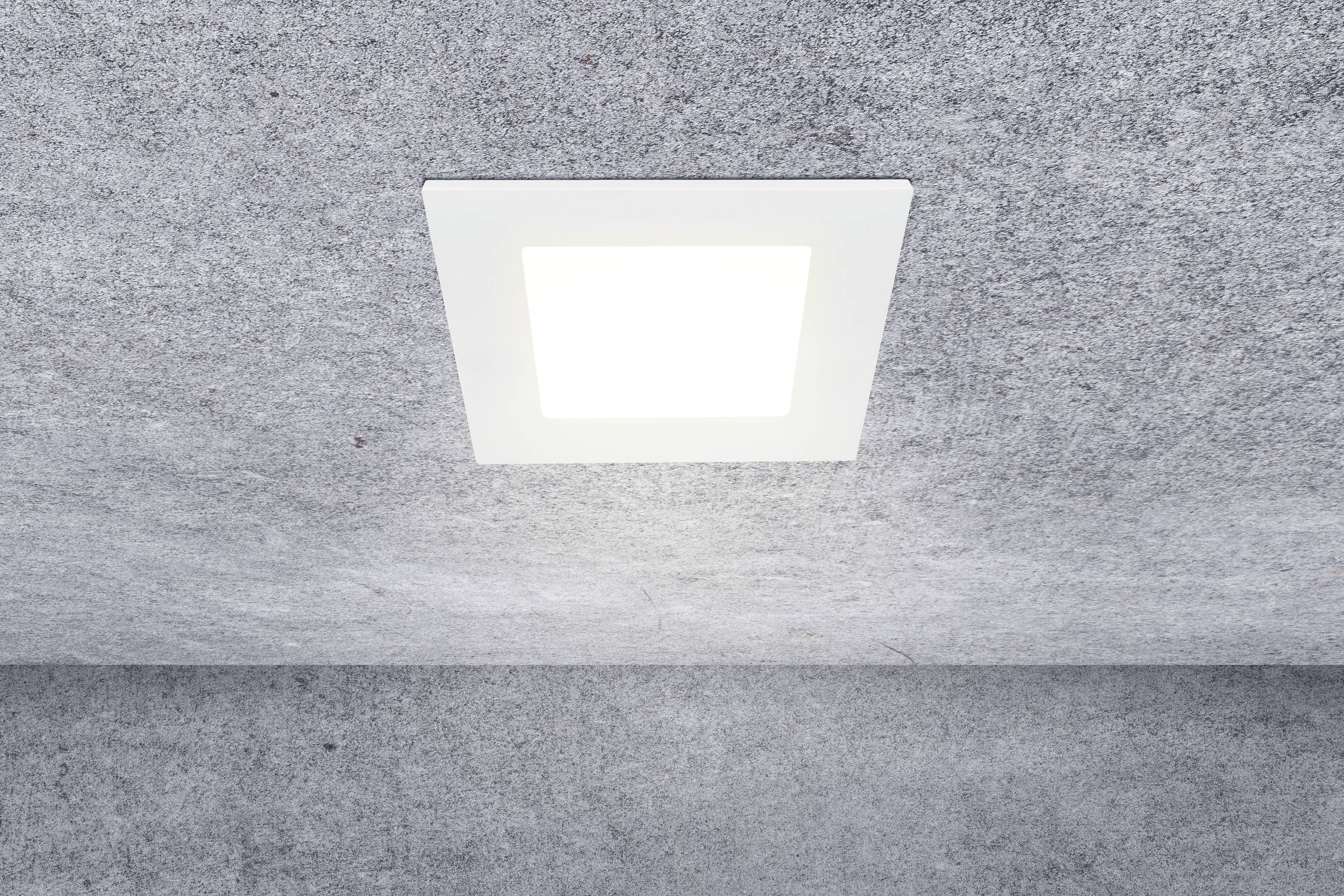 A square ceiling light emits bright light in a room with a grey ceiling.