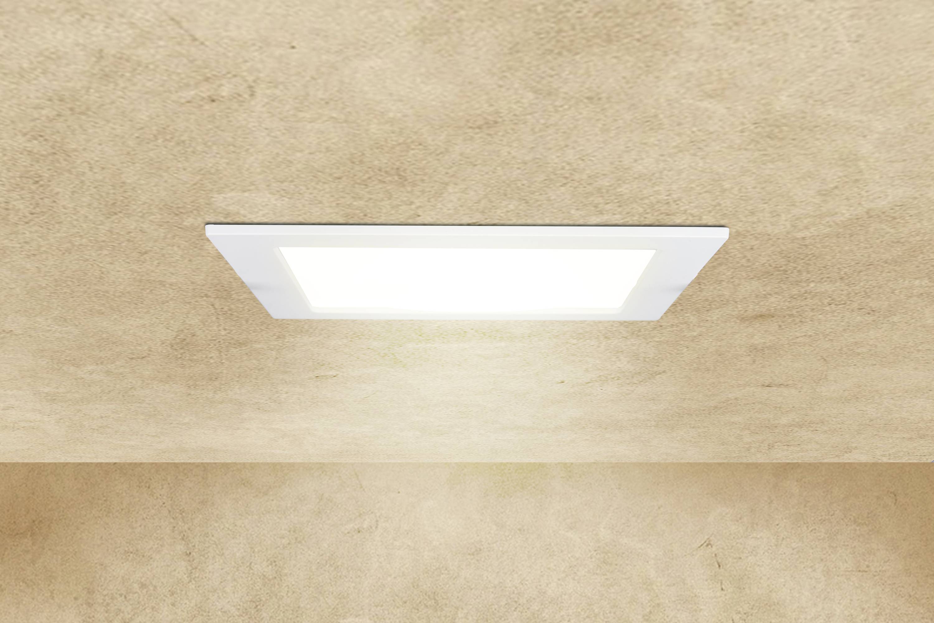 Rectangular ceiling light shines brightly on a beige ceiling.