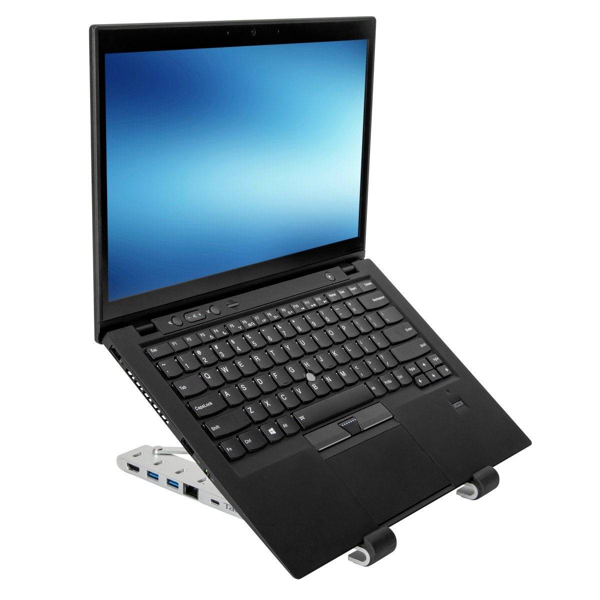 A black laptop on an adjustable stand displays a luminous blue screen background. In the background: a light gradient.