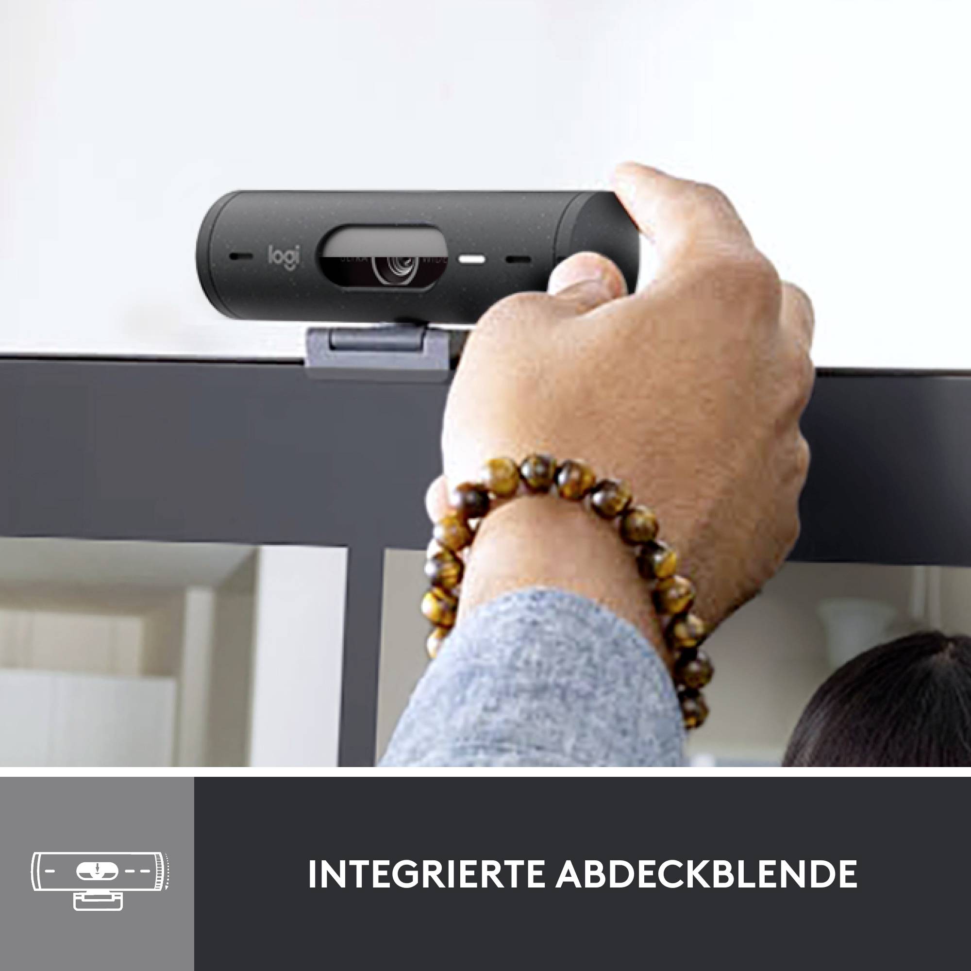 A hand lifts the privacy cover of a mounted webcam to reveal it. Underneath reads 'Integrated Privacy Cover'.