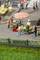 A miniature view of a bustling marketplace with several figures at stalls beneath a red and white parasol.