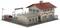 Model of a two-storey building with a red roof, surrounded by a fence. Behind it stands a smaller extension and a large tank.