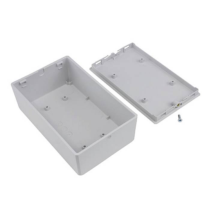 Rectangular grey plastic casing with cover removed, four mounting points and a small screw visible.
