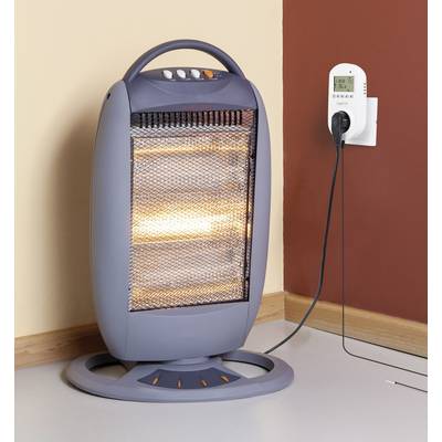 An electric heater is standing in the corner of a room, plugged into a socket. Heating elements are visible.