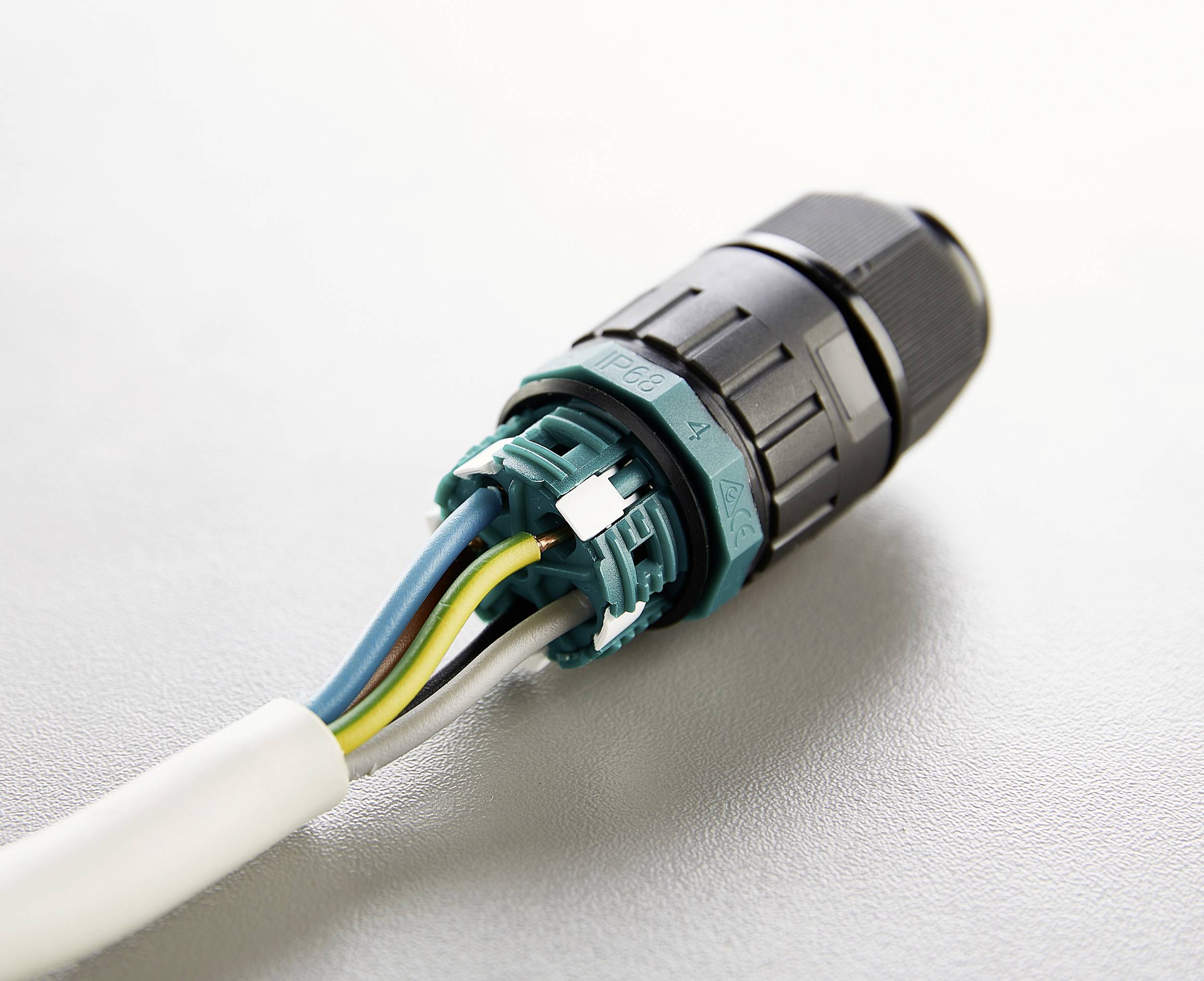 An electrical connector with exposed, coloured wires secured in a black and turquoise housing.