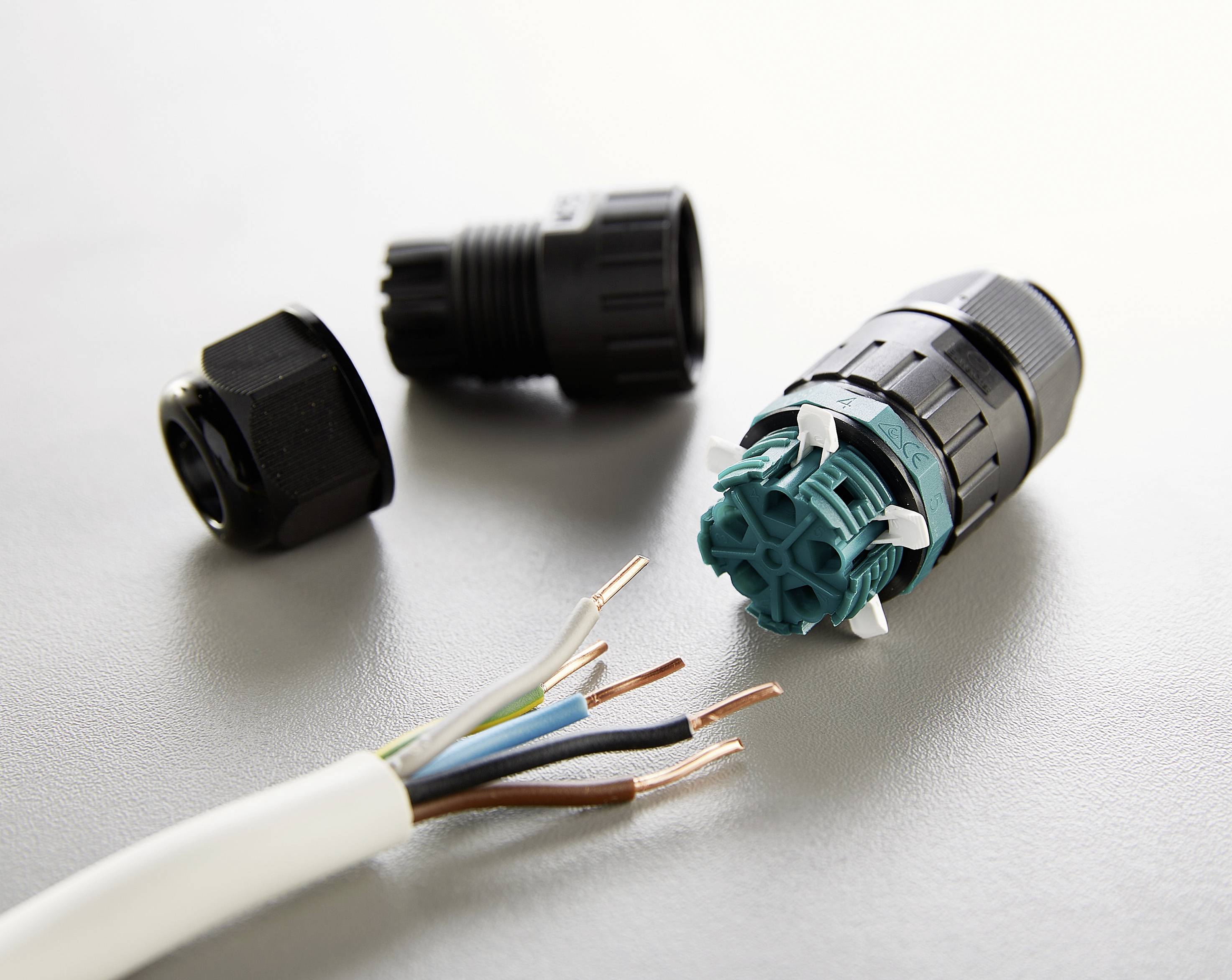 Three cables emerge from a white sheath. Beside them lie three plug components, one partially opened.