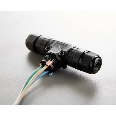 A black T-shaped cable connector with multiple coloured wires, lying on a grey surface.