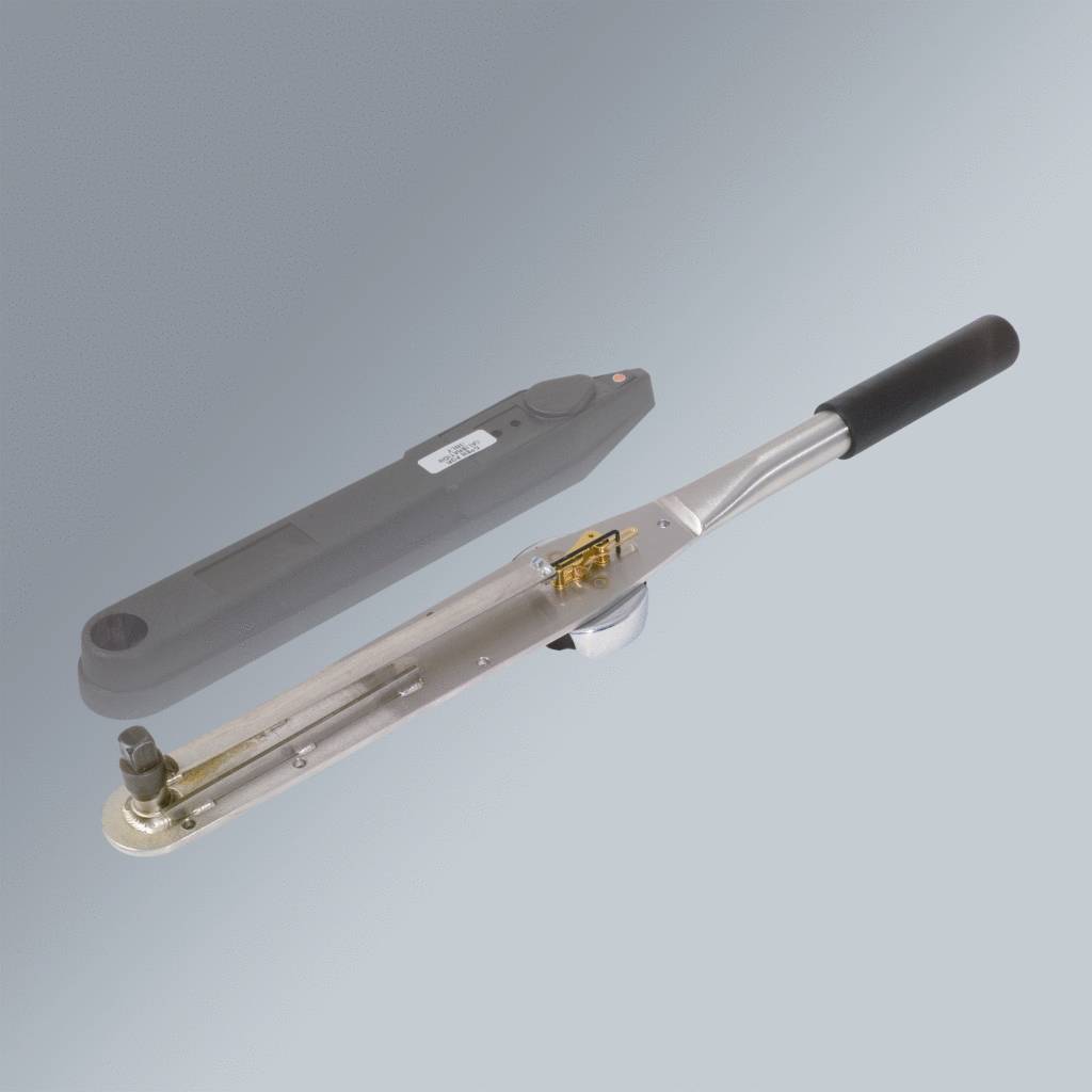 A silver torque wrench with a black handle lies diagonally. Next to it is a protective cover.