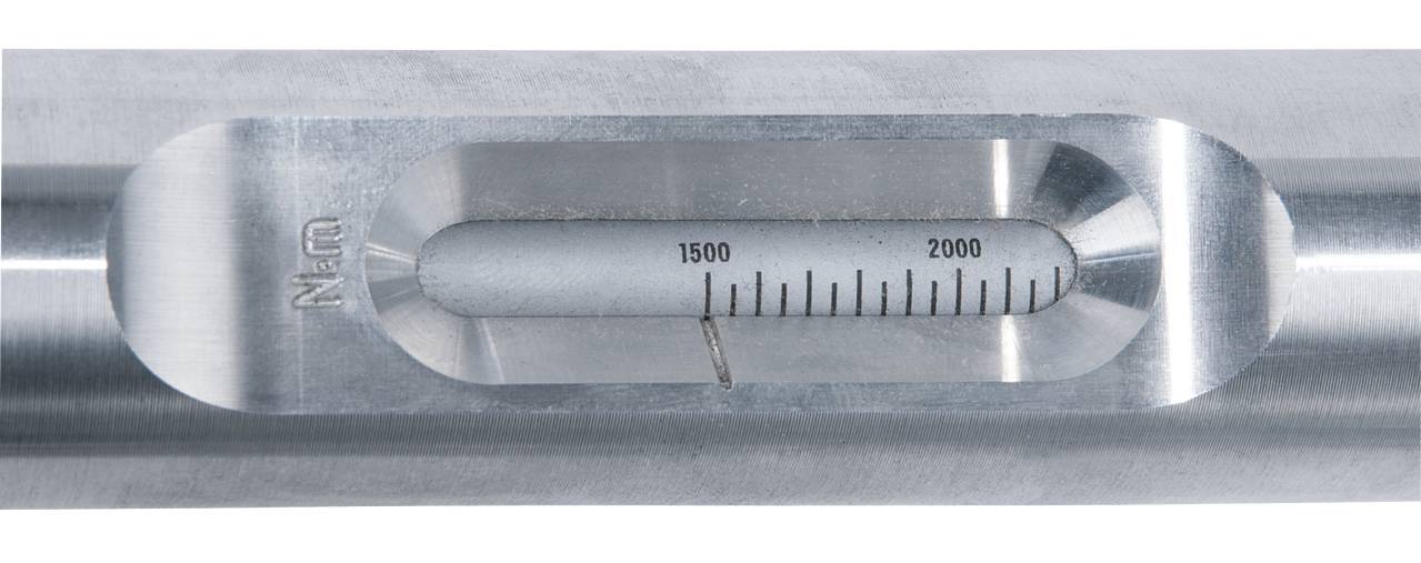 Close-up of a metal bar with an engraved scale from 1500 to 2000 Nm. Device for torque measurements.