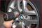 A tyre is being fitted with an impact wrench. The alloy wheel is silver in colour and has a BMW logo in the centre.