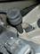 Close-up of a black automotive component with a lever on a metal surface, potentially part of a gearbox or engine connection.
